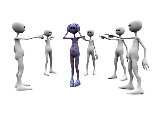 An angry group of white figures standing in a circle, pointing finger at a dotted figure in the middle.